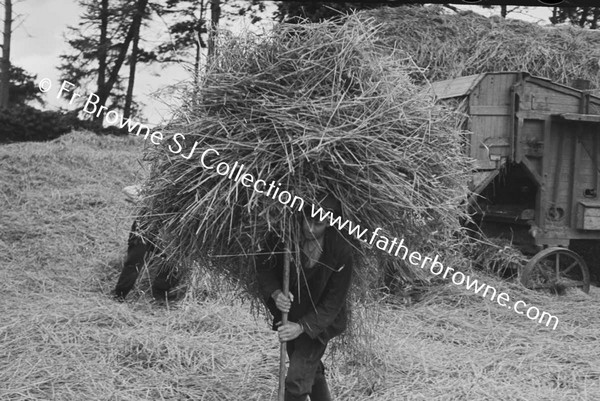 THRESHING SCENE MAN CARRYING LOAD OF HAY ON PITCH FORK